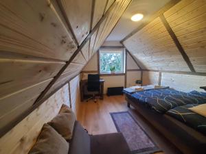 a bedroom with a large bed in a wooden attic at Chata za Świerkami in Nowa Ruda