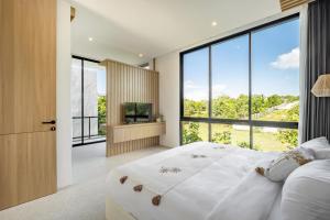 ein Schlafzimmer mit großem Bett und großen Fenstern in der Unterkunft Private Villa Ayra 9C By OriVista 10min to Melasti Beach in Uluwatu + 32 Fotos