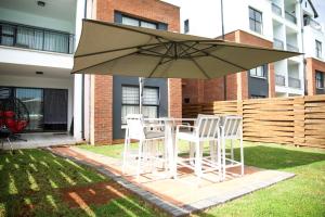 a table and chairs under an umbrella in a yard at The Blyde lagoon facing Pretoria in Pretoria