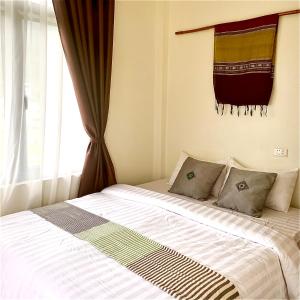 a bedroom with a large bed with a window at Mộc Nhiên Homstay Mai Chau in Hòa Bình