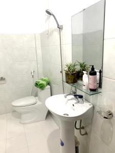 a white bathroom with a toilet and a sink at Mộc Nhiên Homstay Mai Chau in Hòa Bình