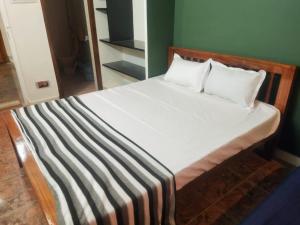 a bed with white sheets and pillows in a room at Private Villa With Swimming Pool at White Town in Puducherry +14 photos