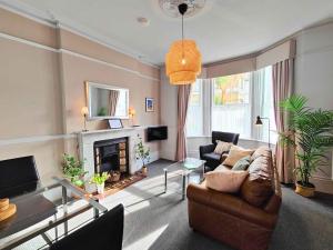 a living room with a couch and a fireplace at Fernhurst holiday apartments in Shanklin