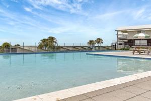 una grande piscina di fronte a un edificio di Finns at Caves Beach Resort a Caves Beach