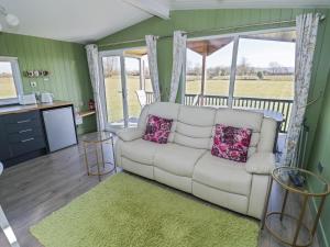 a living room with a white couch and windows at Cotswold View 1 in Evesham