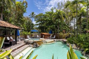 a swimming pool with a waterfall in a resort at Hibiscus POOL VIEW Villa 49b in Port Douglas