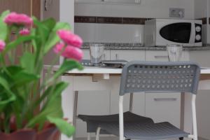 a kitchen with a chair in front of a counter at Apartamentos Niza in Benidorm