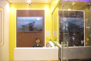 a man in a room with a picture of a seal at Bed Station AC Dormitory in Varanasi