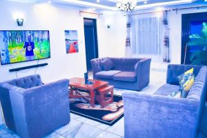 a living room with blue chairs and a table at 5 bedroom bungalow in Kisumu City in Kisumu