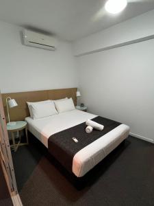 una camera da letto con un letto grande in una stanza di Pandanas Apt 2 (10th floor, Pool & City views) a Darwin