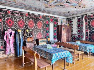una stanza con due tavoli e una parete ricoperta di carta da parati di Reyhana Unique House a Samarkand