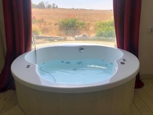 uma banheira em um quarto com janela em אלרון - אירוח בגולן em Ani'am mais 64 fotografias