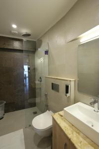 a bathroom with a toilet and a sink and a shower at Bummy's by Vyaana Retreats in Mussoorie +34 photos