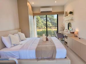 ein Schlafzimmer mit einem großen Bett mit einem großen Fenster in der Unterkunft Sixty-one Pool Villa Khaoyai รองรับสูงสุด 14 ท่าน, up to 14 people in Ban Bung Toei + 18 Fotos