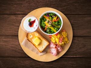 a plate with a sandwich and a salad and a bowl of dip at LUXCARE HOTEL in Osaka