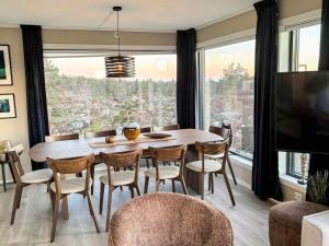 a dining room with a table and chairs and a large window at 6 person holiday home in Søndeled-By Traum in Søndeled