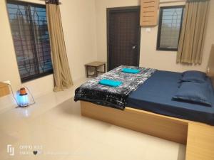 a bedroom with a bed with blue pillows on it at Kookee Villa in Hātgarh