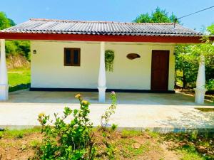 a small white house with a red roof at Hena Villas Campsite in Kataragama