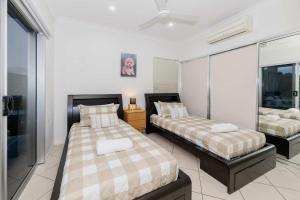 Giường trong phòng chung tại Ocean-View Penthouse on The Strand, Townsville - 3 Bedrooms +9 ảnh