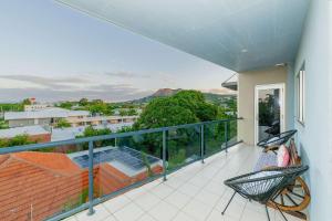 a balcony with two chairs and a view at 3BR Oceanfront Penthouse on The Strand, Townsville in North Ward