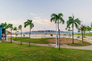 a park with palm trees and a beach at 3BR Oceanfront Penthouse on The Strand, Townsville in North Ward