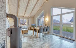 a dining room with a fireplace and a table with chairs at 2 Bedroom Amazing Home In Dagebüll in Dagebüll