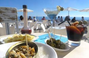 a table topped with plates of food and a drink at Apartamento Cabrera Burriac in Cabrera de Mar