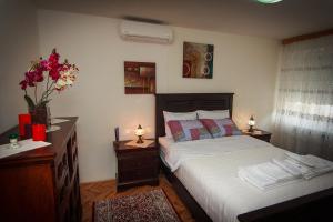 a bedroom with a bed and a dresser with two lamps at Apartment Red House in Visoko