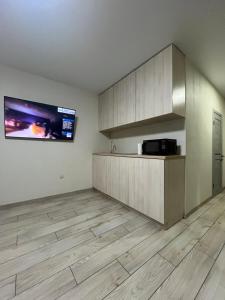 an empty room with a kitchen with wooden floors at Perlina Dnipra in Kyiv