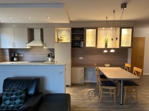ボルテンハーゲンにあるFerienwohnung Skipper, strandnah mit Whirlpoolのテーブルと椅子のあるキッチンとダイニングルーム +16枚の写真