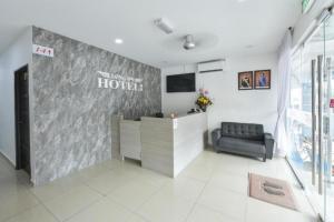 a hotel lobby with a reception desk and a couch at Song 99 Hotel in Simpang Renggam +4 photos