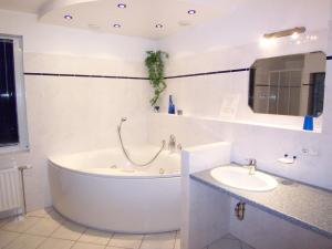 ボルテンハーゲンにあるFerienwohnung Skipper, strandnah mit Whirlpoolの浴槽と洗面台のある白いバスルーム