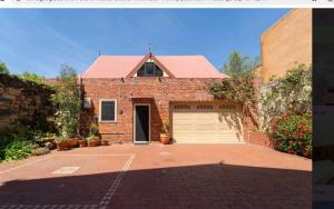 a brick house with a garage and a driveway at Snow white's 2 bedroom dream Cottage with free parking in Perth