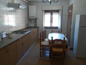 スアンセスにあるvivienda la palmeraのテーブルと椅子と冷蔵庫のあるキッチン