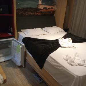 a bed with white towels on top of it at Bahia Astron Mundial Hotel Flats in Salvador