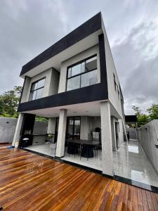 a modern house with a wooden floor and a deck at Mansão Luxuosa em Condominio in Belo Horizonte
