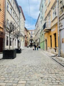 a cobblestone street in a city with buildings at Апартаменти в центрі старого Львова in Lviv