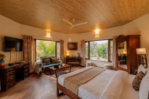 a bedroom with a bed and a desk and a tv at SaffronStays Casa Octavia in Bhīm Tāl