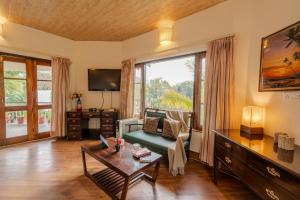 a living room with a couch and a table at SaffronStays Casa Octavia in Bhīm Tāl