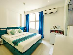 a bedroom with a large bed with blue curtains at Planktons Beach in Hulhumale +35 photos