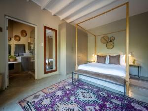 a bedroom with a canopy bed and a rug at eKhaya Bush Lodge in Hoedspruit