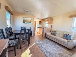 a living room with a couch and a table at 6 Berth Caravan For Hire With Decking At Manor Park In Norfolk Ref 23017S in Hunstanton