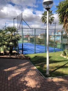 a tennis court with a net in a park at Casa Monte y Faro in Santa Pola
