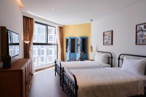 ein Hotelzimmer mit zwei Betten und einem Fenster in der Unterkunft The Apec Mandala Ocean View Mui Ne - Condotel in Mui Ne