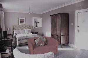 a bedroom with a bed and a couch and a chair at The Kirkcudbright Bay Hotel in Kirkcudbright