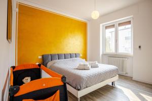 ein Schlafzimmer mit einem Bett und einer gelben Wand in der Unterkunft Garda Art&Lake in Peschiera del Garda