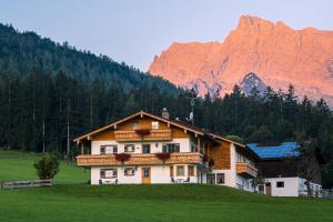a house on a hill with a mountain in the background at Appartements Hochödlehen in Schönau am Königssee