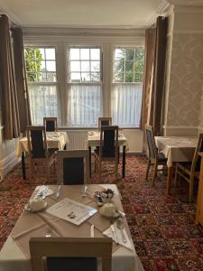 a dining room with tables and chairs and windows at The Sandrock in Clacton-on-Sea