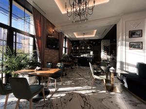 ein Restaurant mit Tischen und Stühlen und einem Kronleuchter in der Unterkunft Hotel Kloest in Durrës