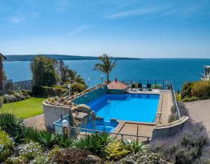 een zwembad met uitzicht op het water bij Breathtaking Clifftop Ocean Views from Unit 12 in Eden